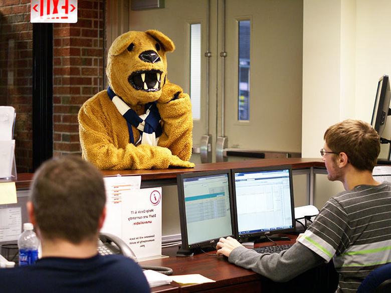 Two service desk consultants provide assistance to the Nittany Lion mascot.